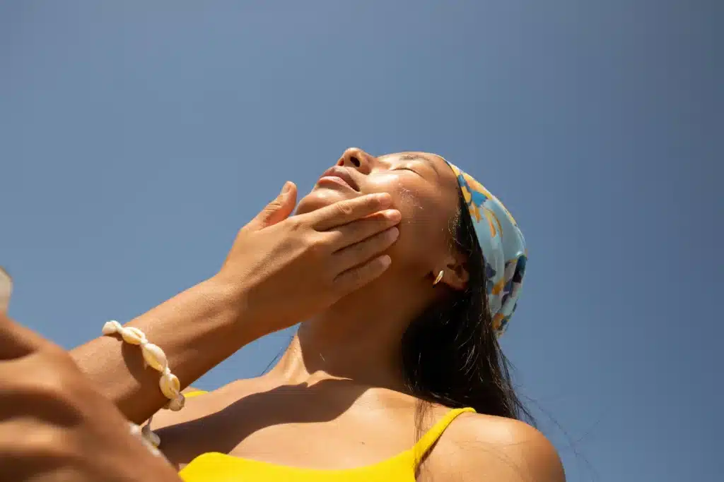 woman applying sunscreen to avoid sun damage or pigmentation damage